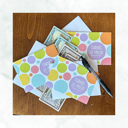 a flat lay photo of thank you cards and cash to demonstrate the gesture of tipping you movers