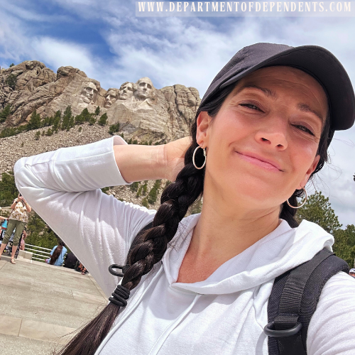 woman poses for a selfie infront of mount rushmore in south dakota