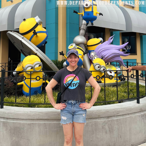 women stands at the entrance of minion land at universal studios in orlando, florida