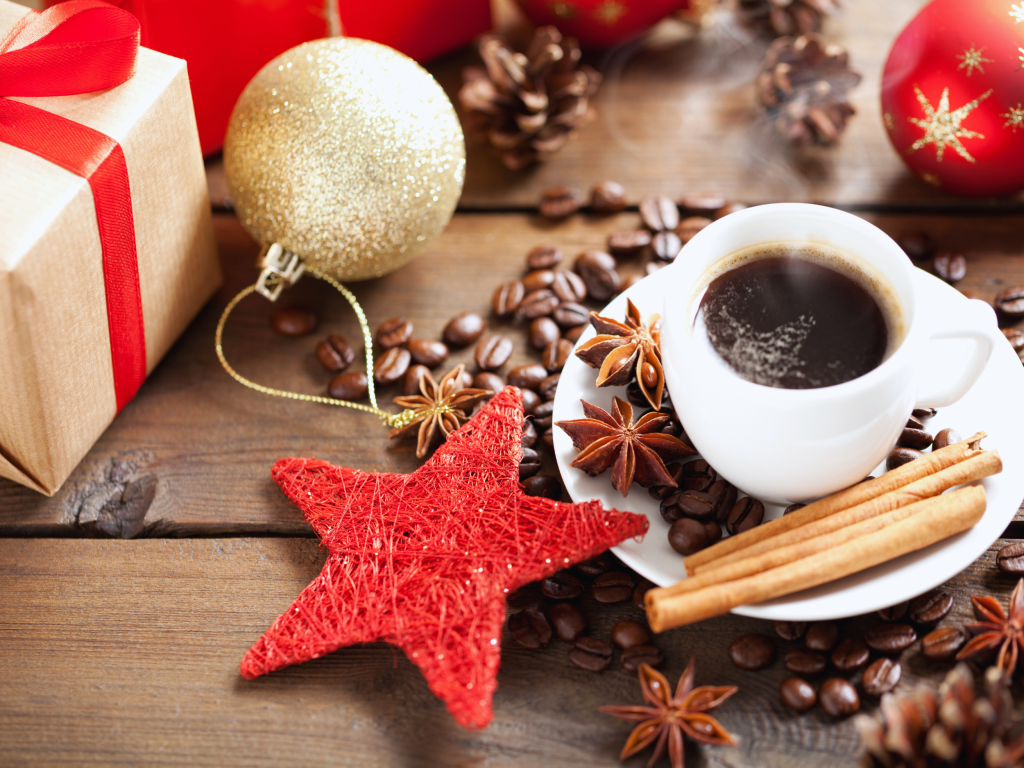 christmas decorations on a table with a cup of coffee